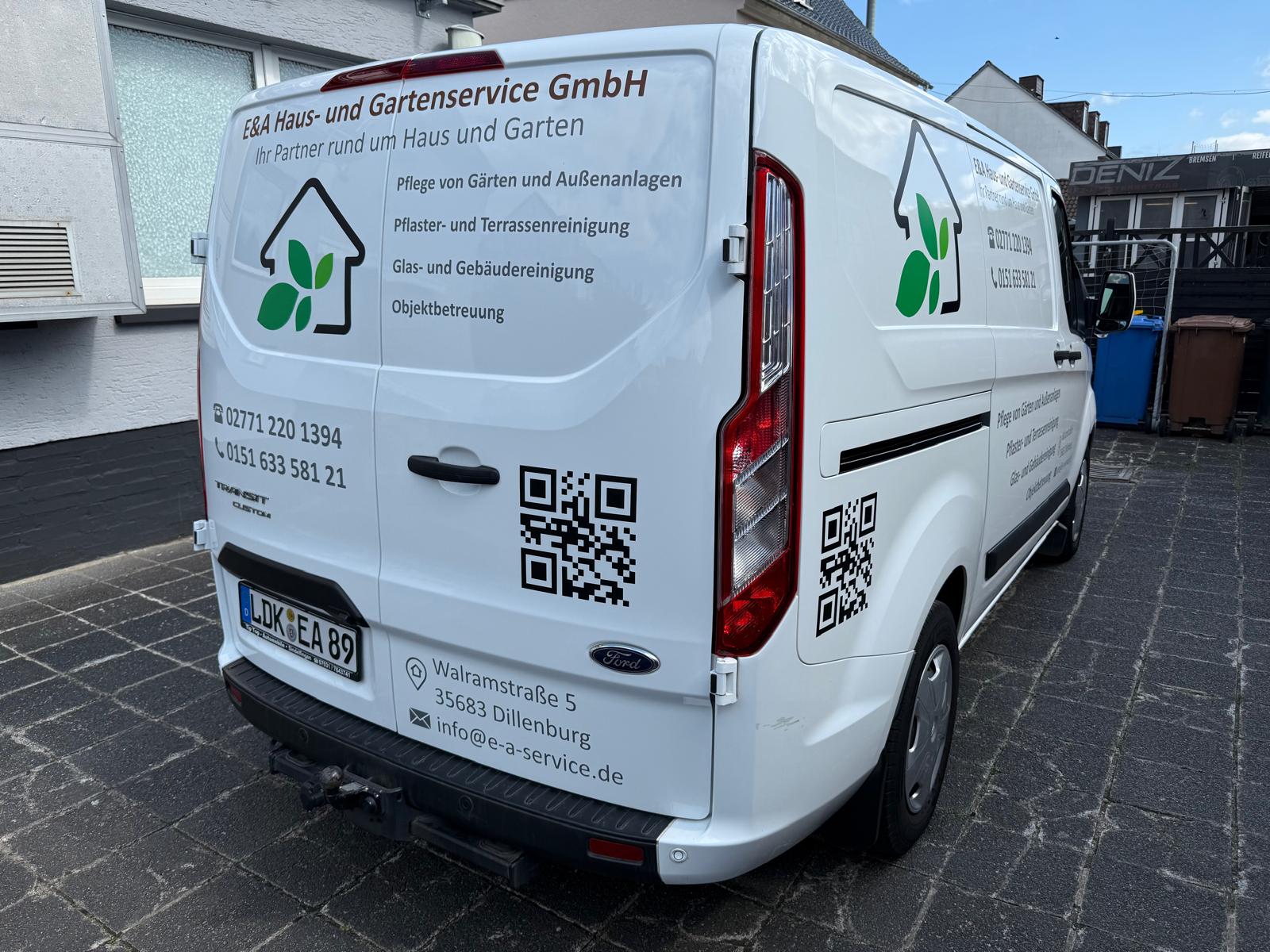 Beschrifteter Firmen-Transporter mit Leistungen und Kontaktdaten